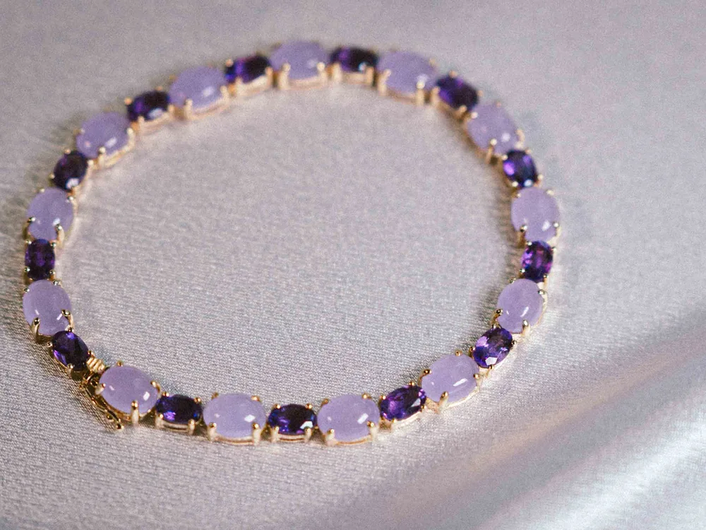 A gold bracelet set with purple gemstones