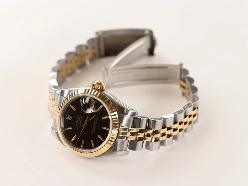 A two-tone gold and steel wristwatch with its clasp open