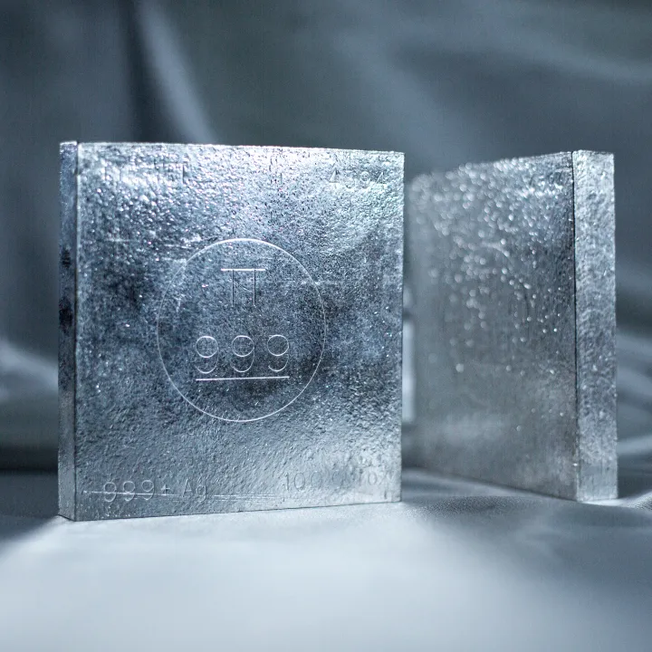 Two stacked 100 ounce fine silver bars stamped 999, standing upright against a soft gray backdrop