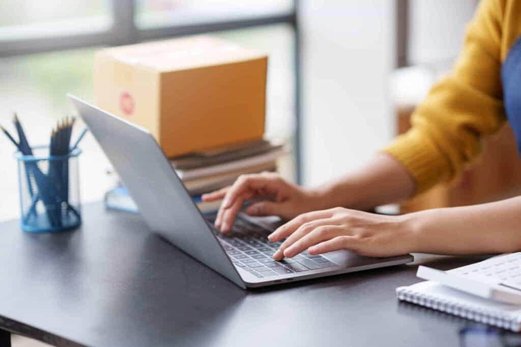 Businesswoman working on laptop with precious metals and documents.