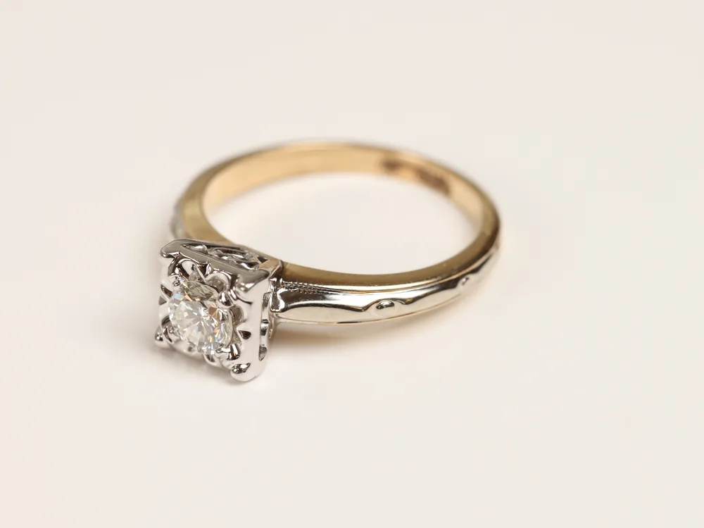 Gold and diamond ring on a cream background