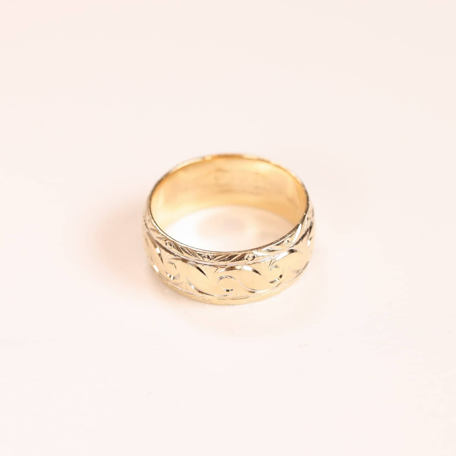 Elegant gold ring with detailed engraving.