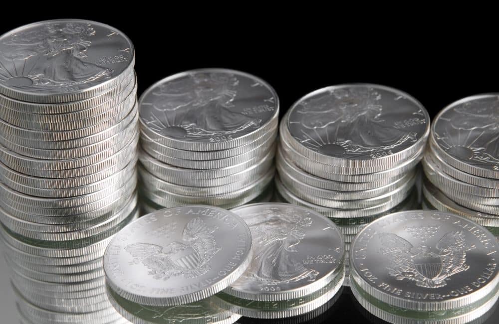 A stack of silver coins on a black surface.
