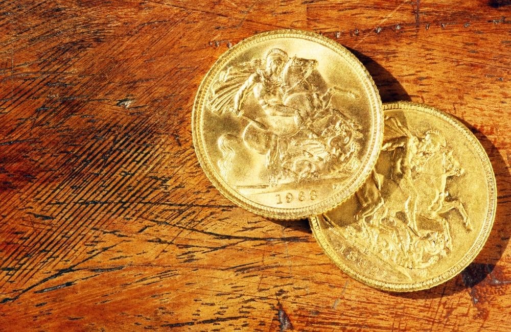Two gold coins on a wooden table.
