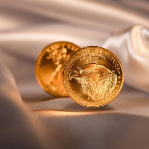 Two gold coins on a silk fabric.
