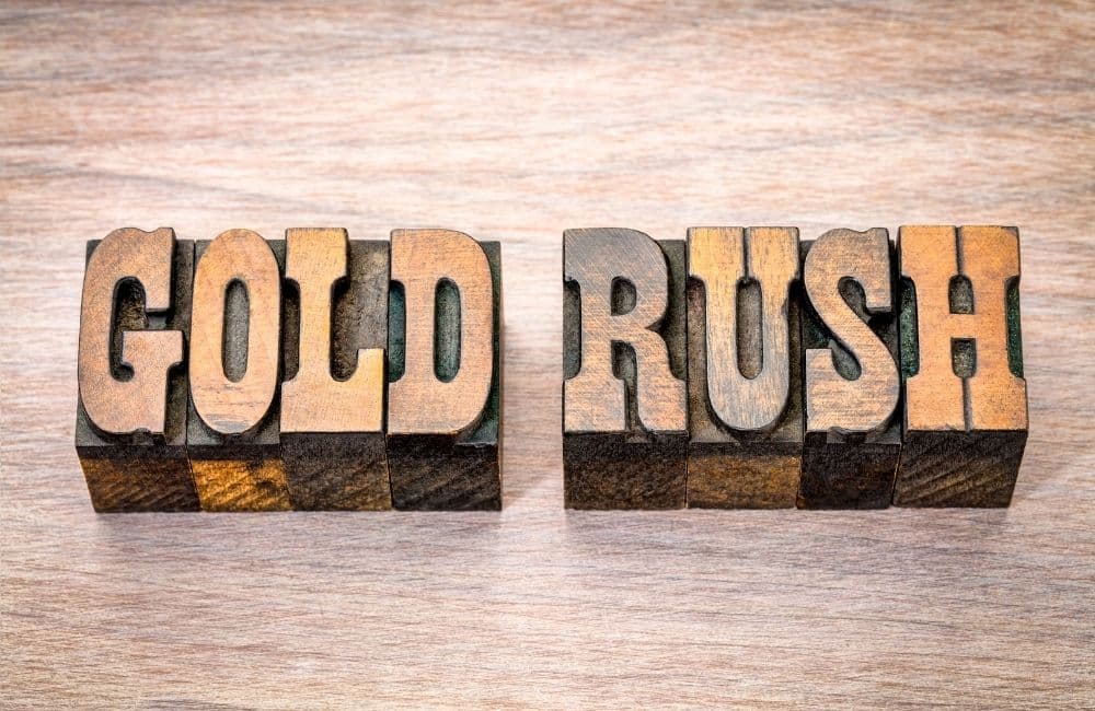 The word gold rush in wood type on a wooden background.