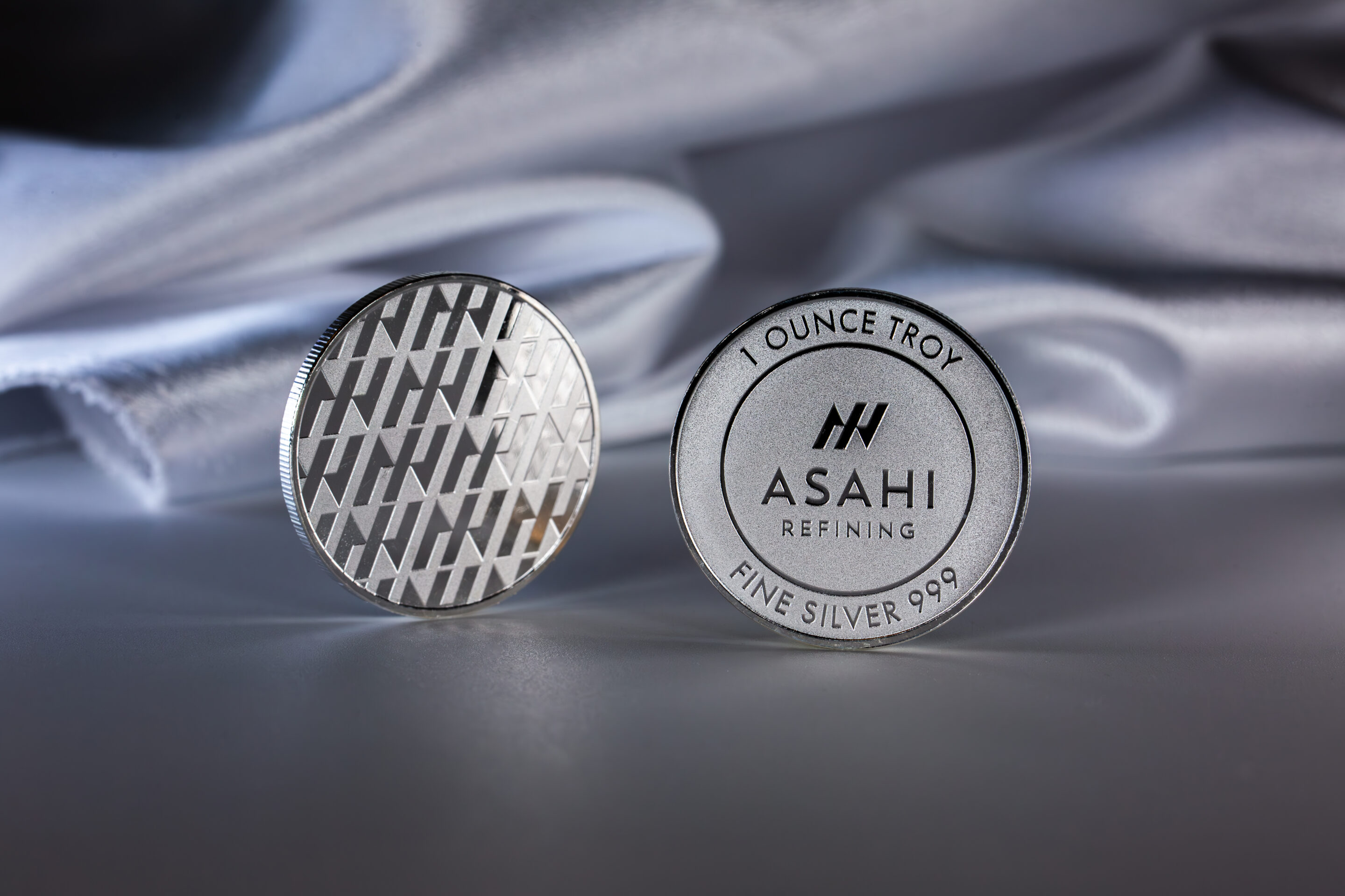 A pair of silver pins with the word ashi on them.