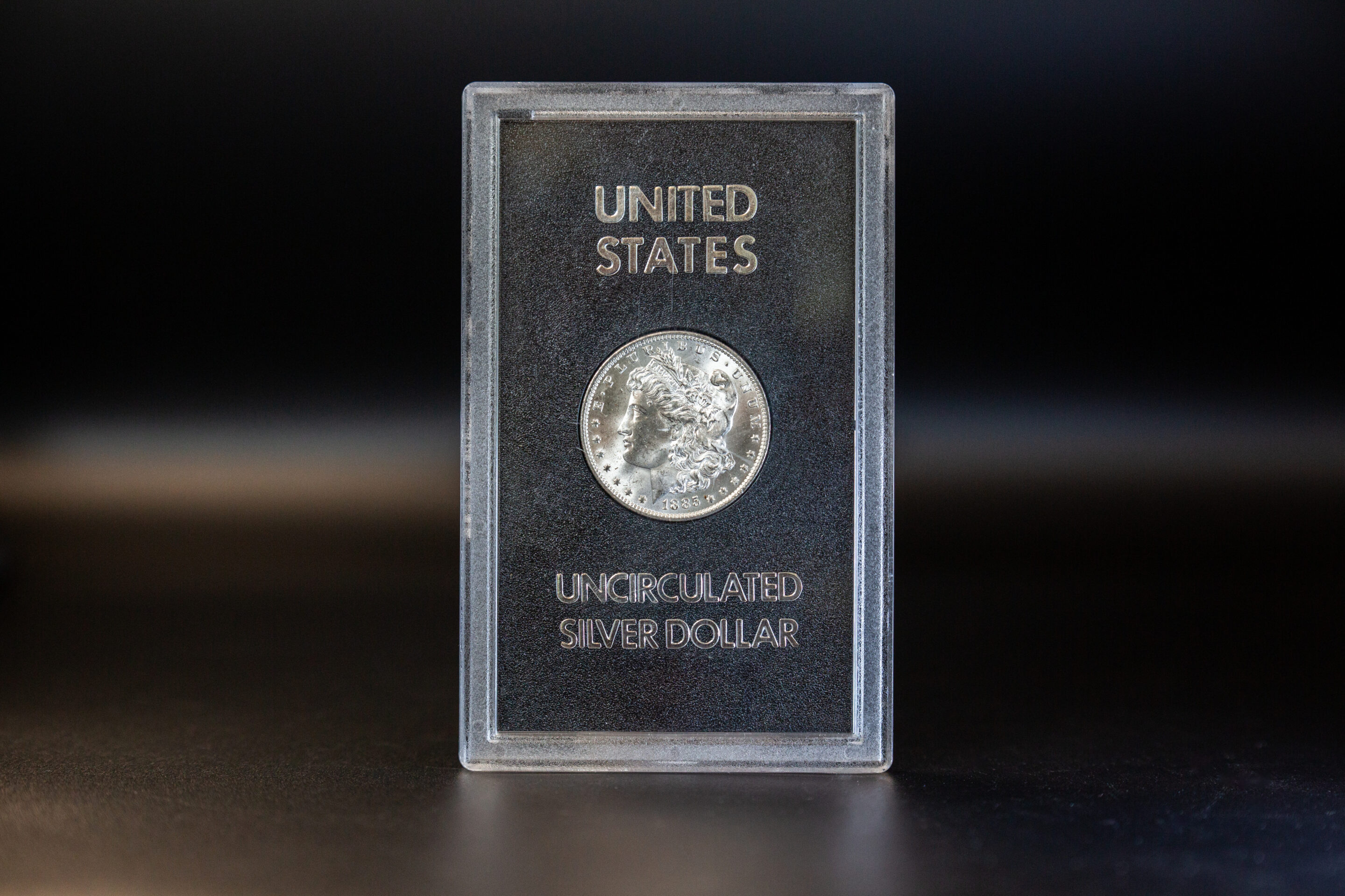A silver dollar in a clear plastic case, now available in a 100 Gram CombiBar version.