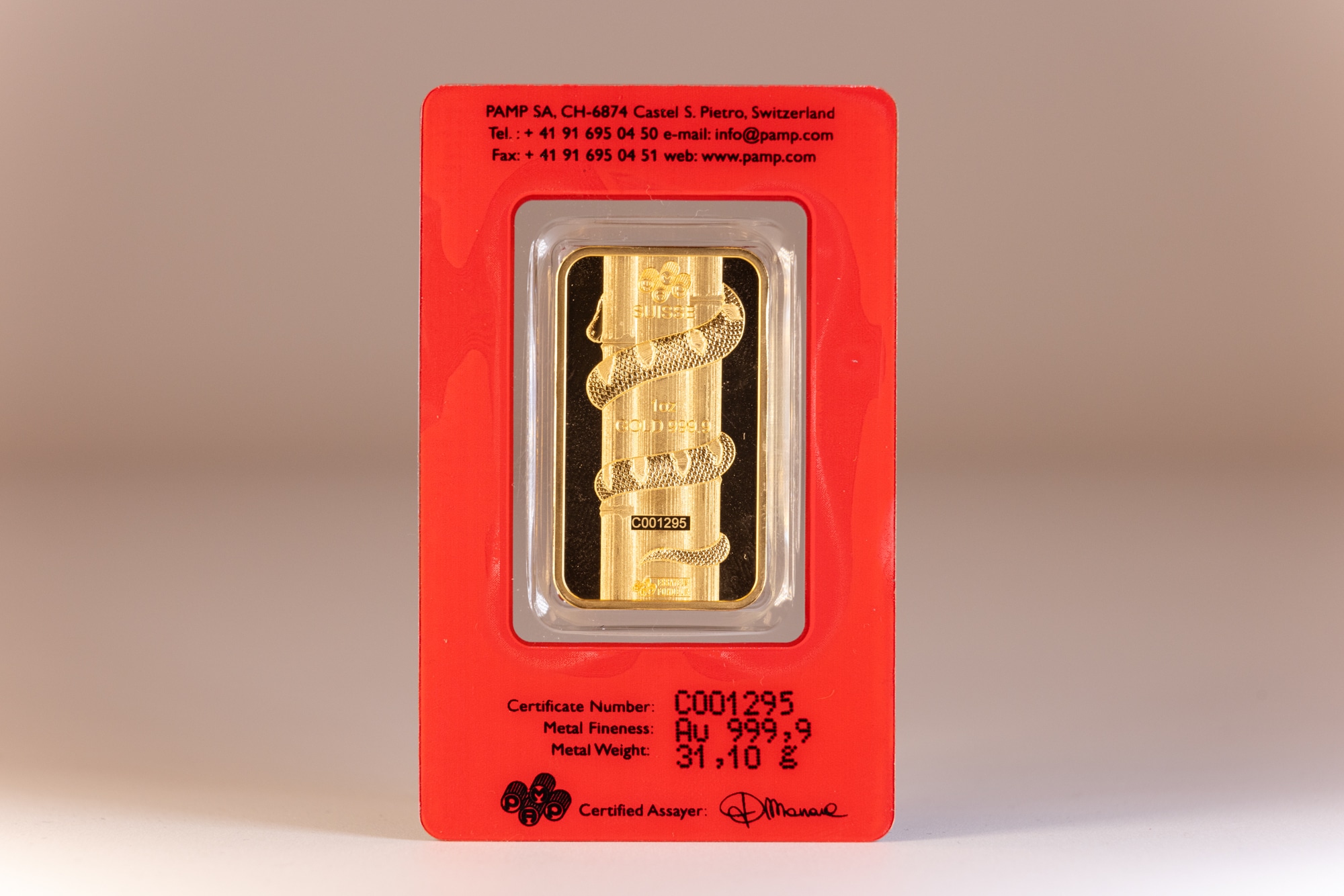 A shiny gold bar featuring a snake design, packaged in the lunar calendar series on a clean white background.