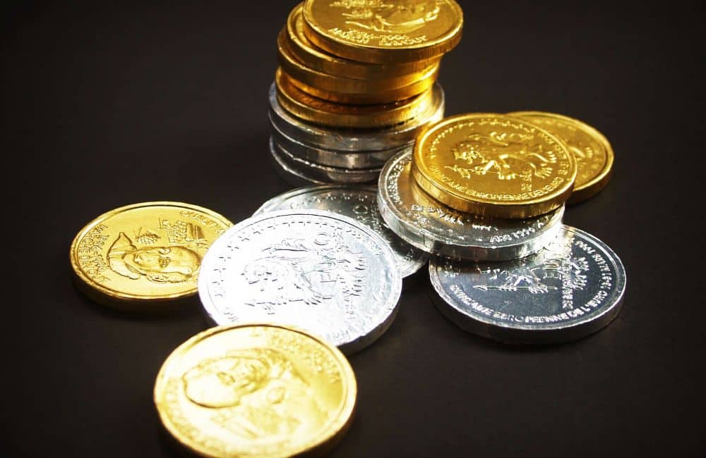 Diverse collection of world coins made from precious metals displayed with national emblems
